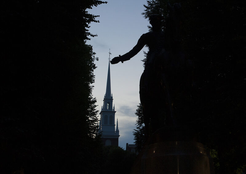 Silhouettes of the statue of Paul Revere and the Old North Church at sundown in the North End.