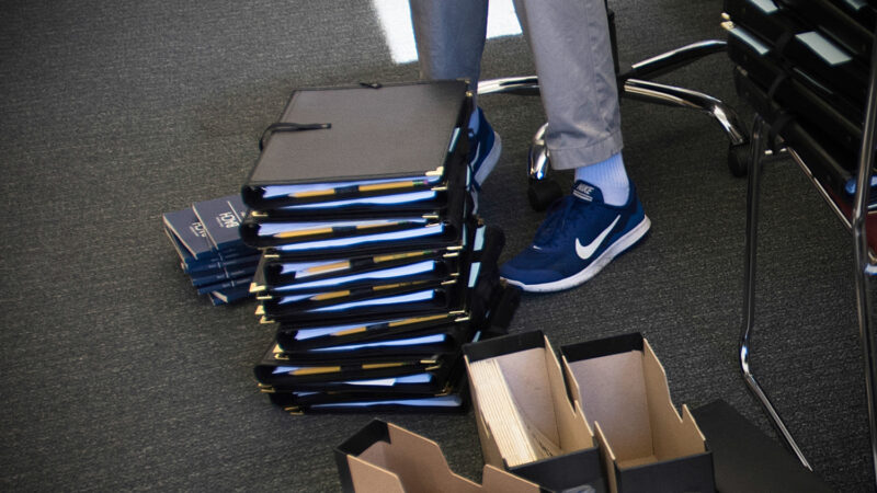 Choirmaster Edward Jones assembles music folders and invitations to new members in preparation of first full rehearsal